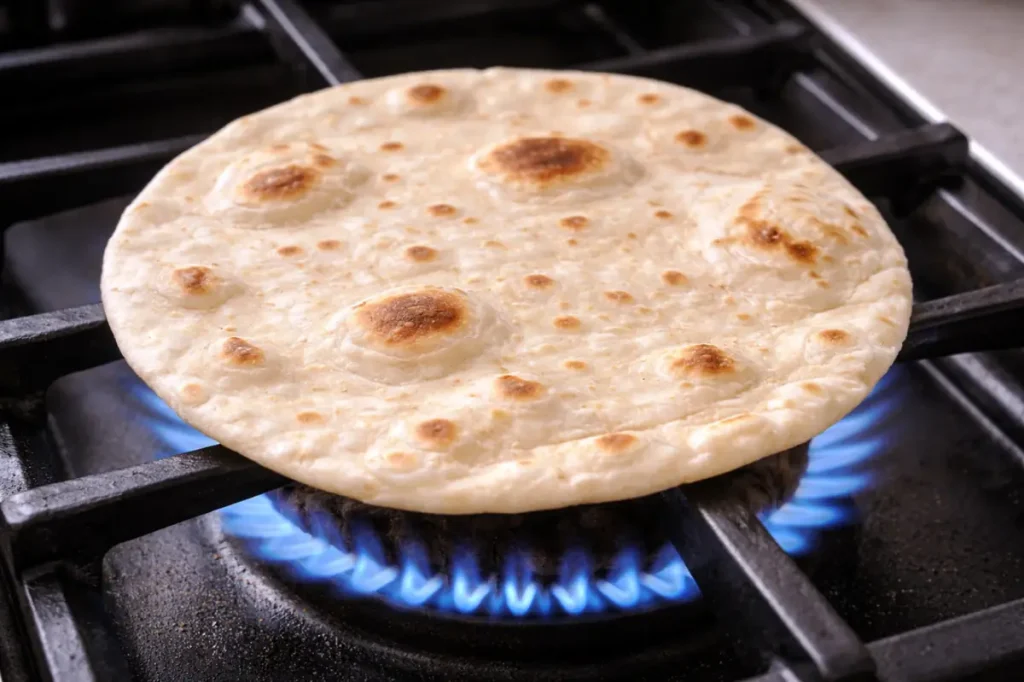 Flour tortillas warming over a gas stove for middle eastern tacos